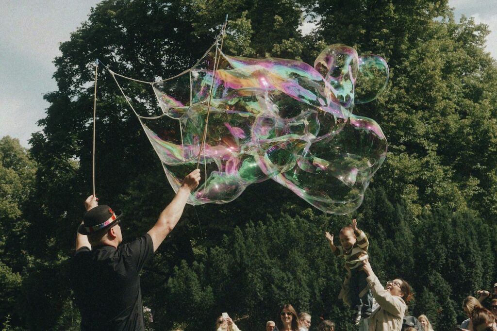 Riesige schillernde Seifenblasen bei einem sommerlichen Grätzlfest in Wien, kuratiert für Familien auf fini.wien.
